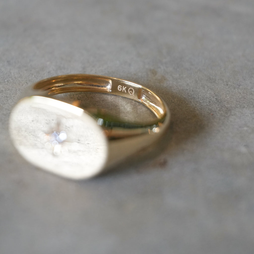 Gold ring with a diamond on a gray surface