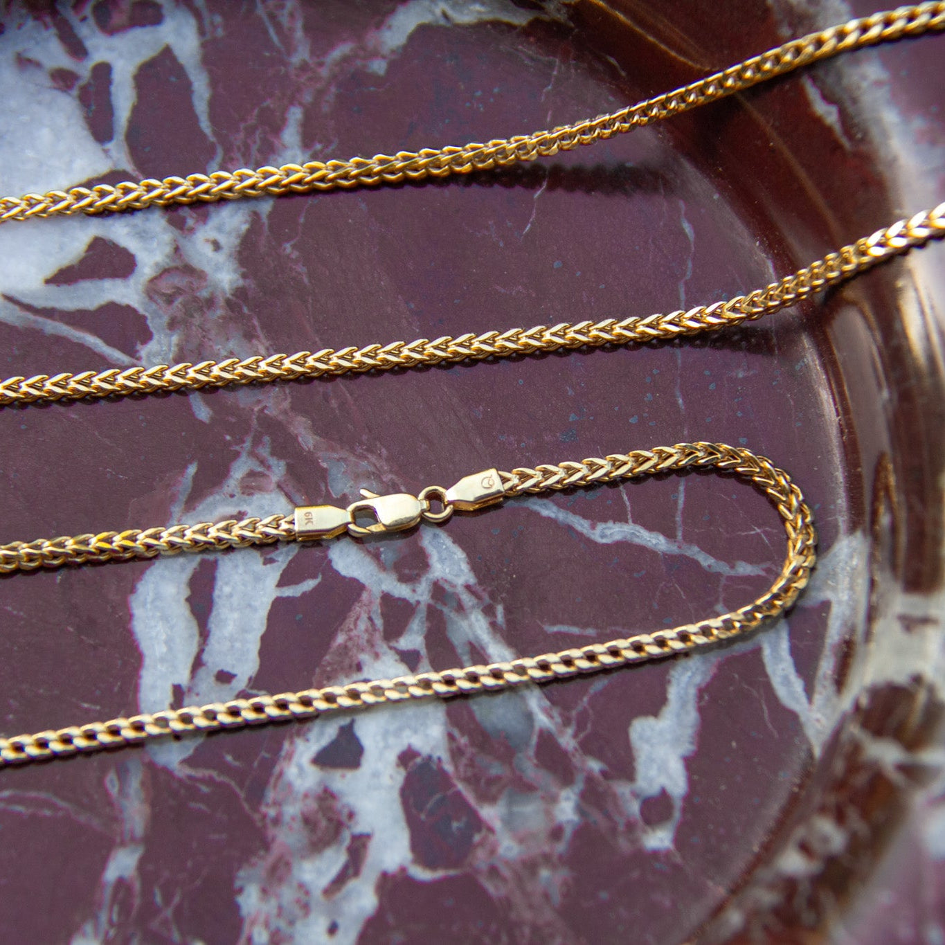 Gold chains on a marbled surface