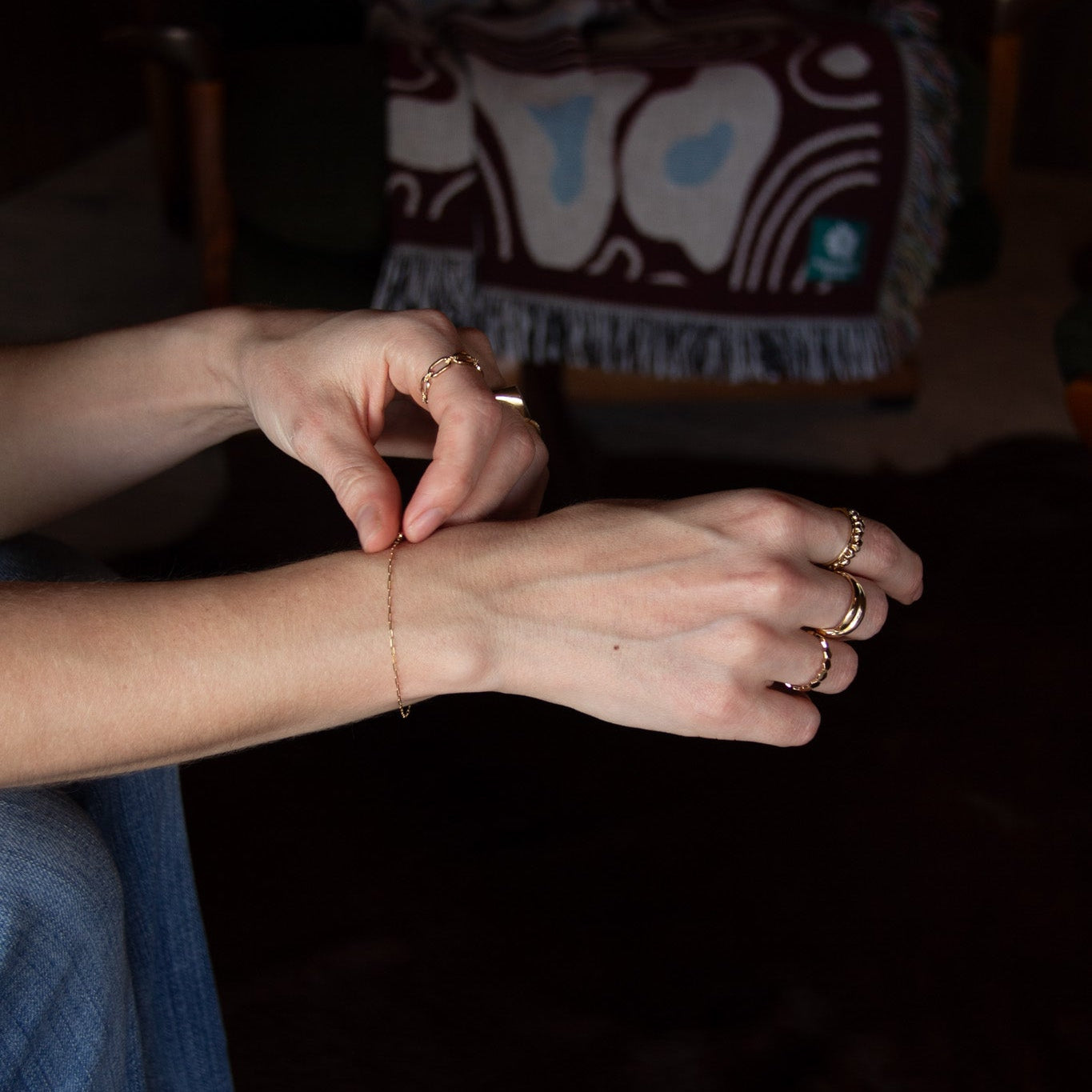 Close-up of a person's hands with rings on a dark background